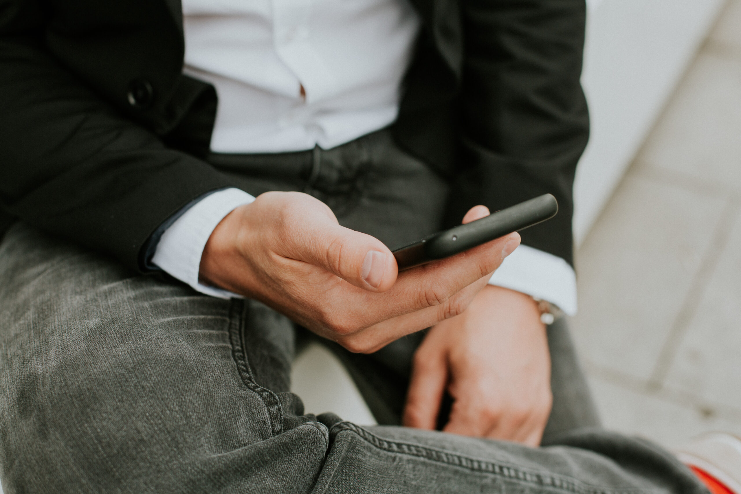 A person using a smartphone to check social media while sitting on the couch
